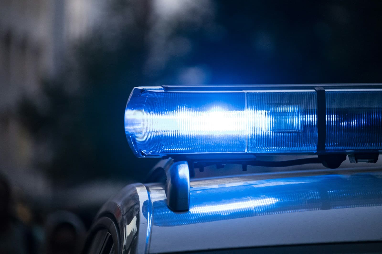 Blue police emergency lights flashing on top of patrol car with blurred background