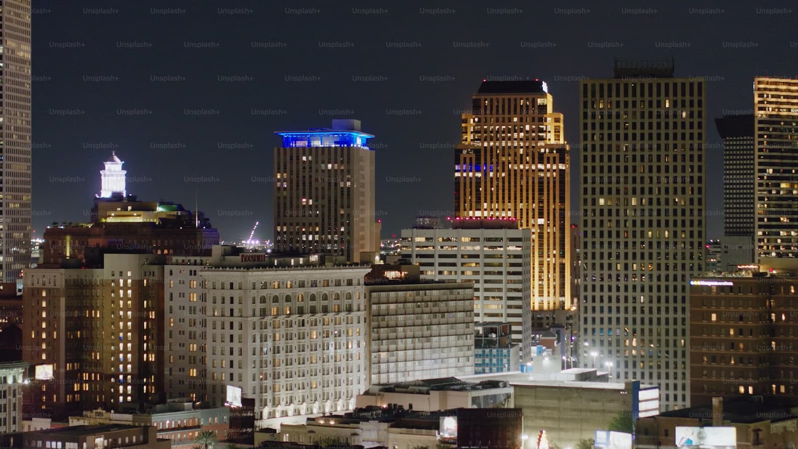 Illuminated downtown city skyline at night with tall buildings and skyscrapers