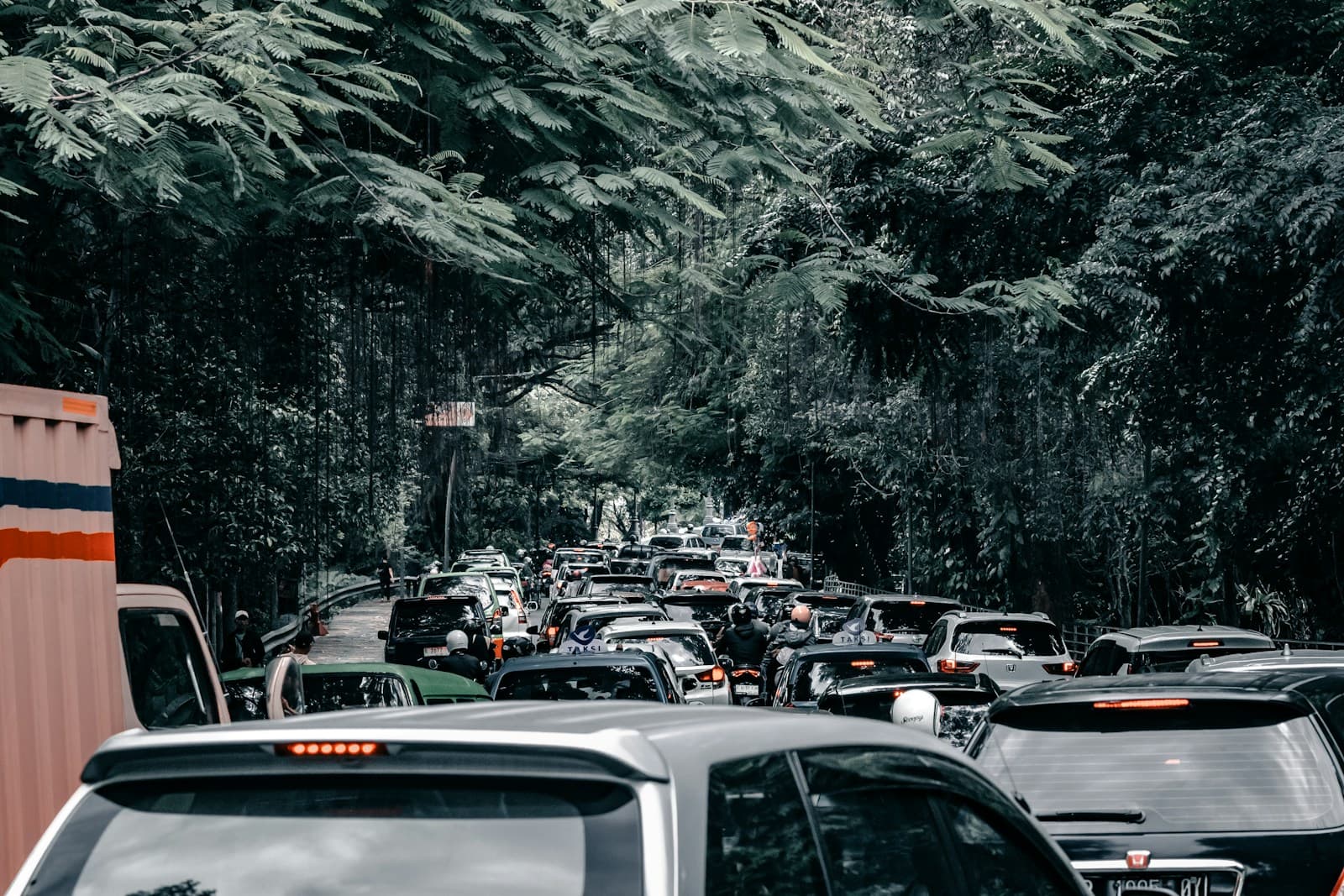 Heavy traffic jam on mountain highway with cars backed up between forested slopes
