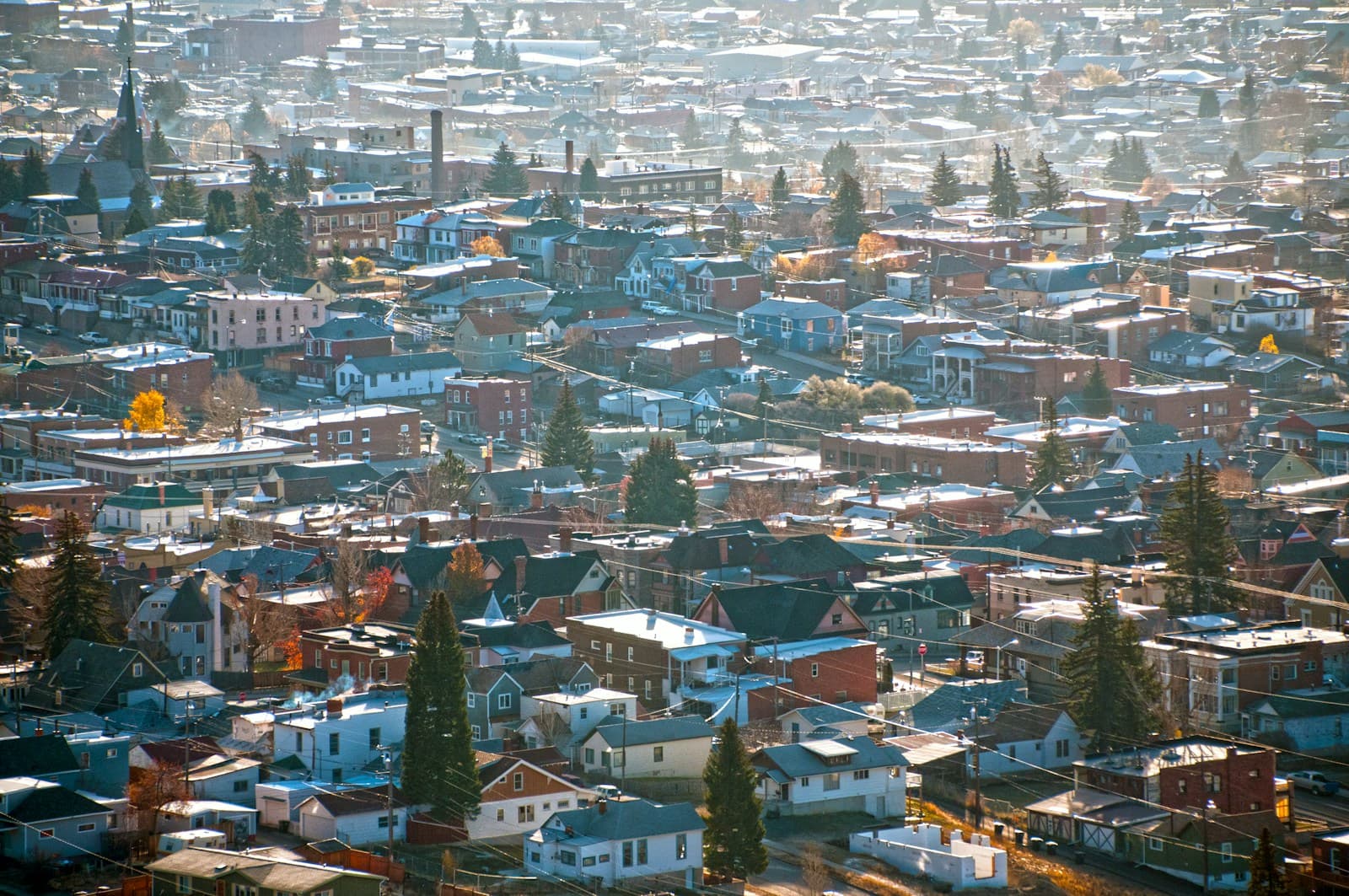 Aerial view of snow-covered residential neighborhood with houses and buildings in winter cityscape