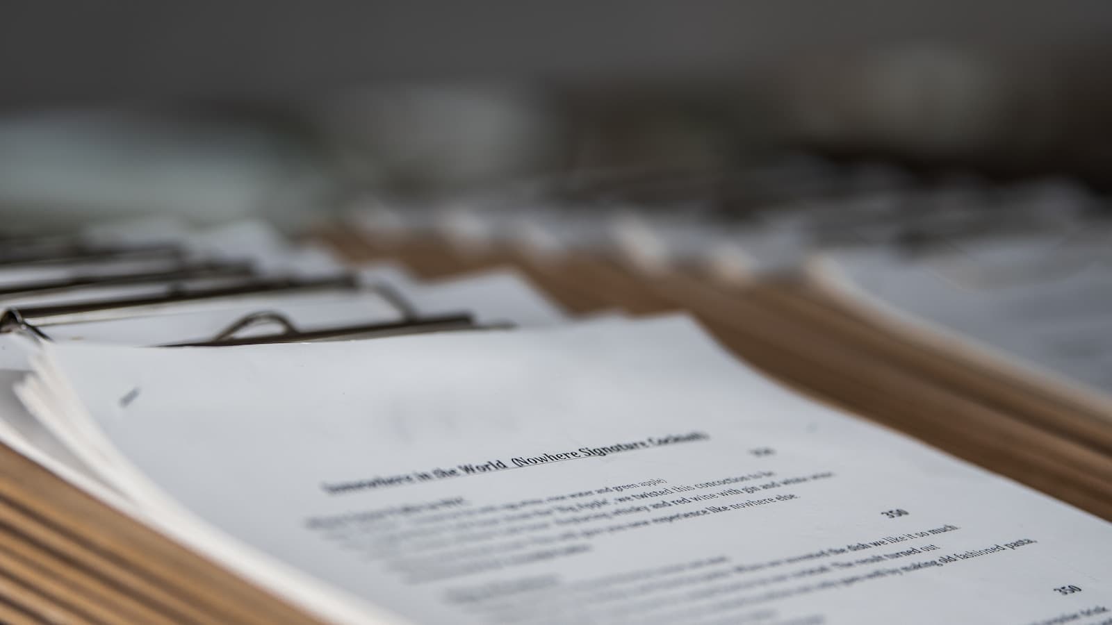 Stacks of white paper documents or forms with printed text arranged on a surface