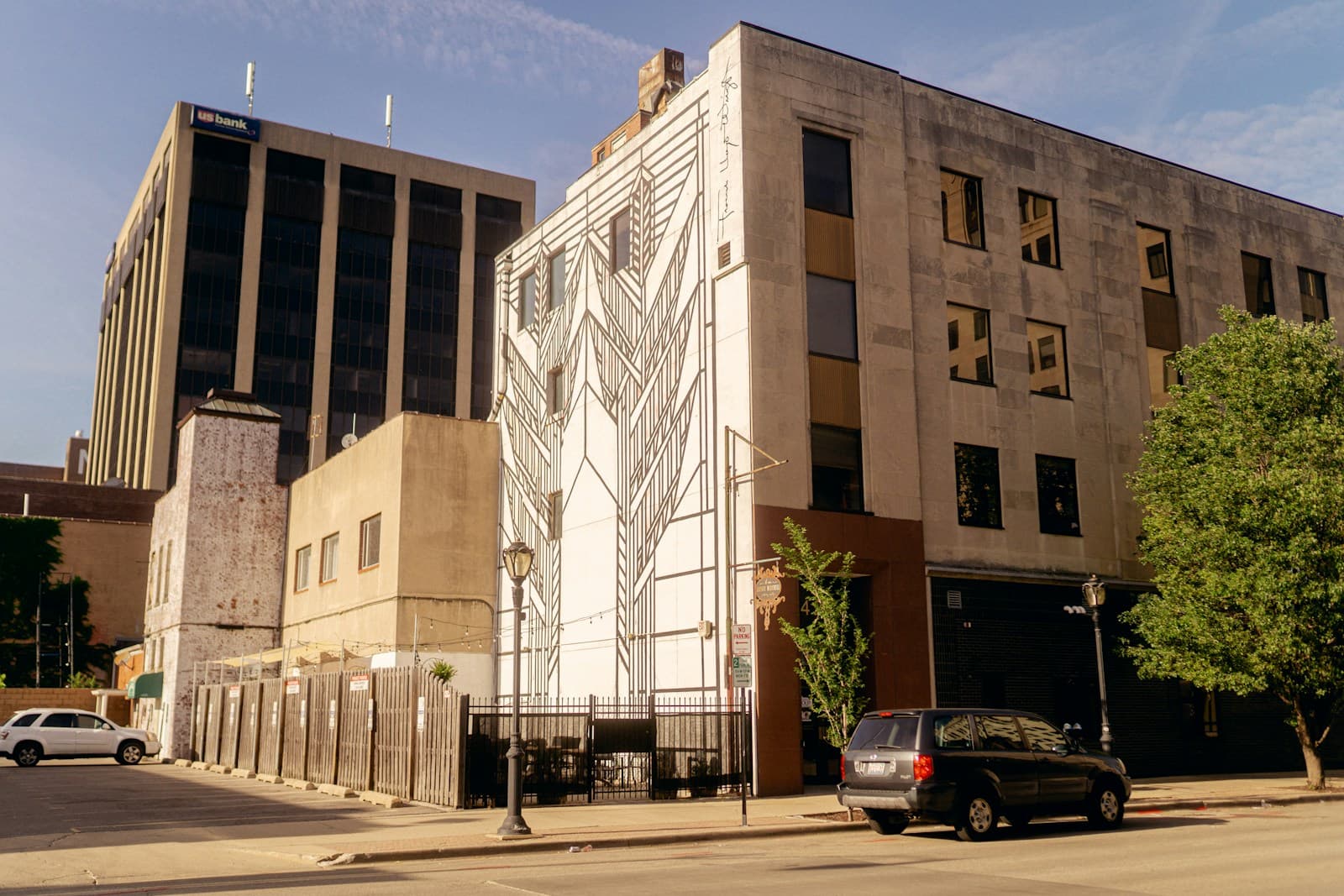 Modern mixed-use building with geometric white facade pattern and traditional brick sections on urban street
