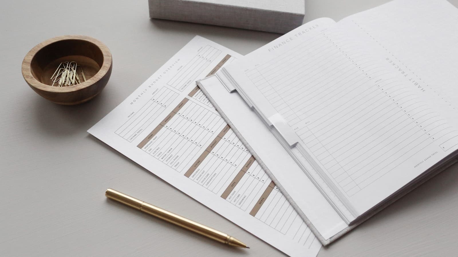 White forms laid out in an overlapping arrangement beside a gold pen