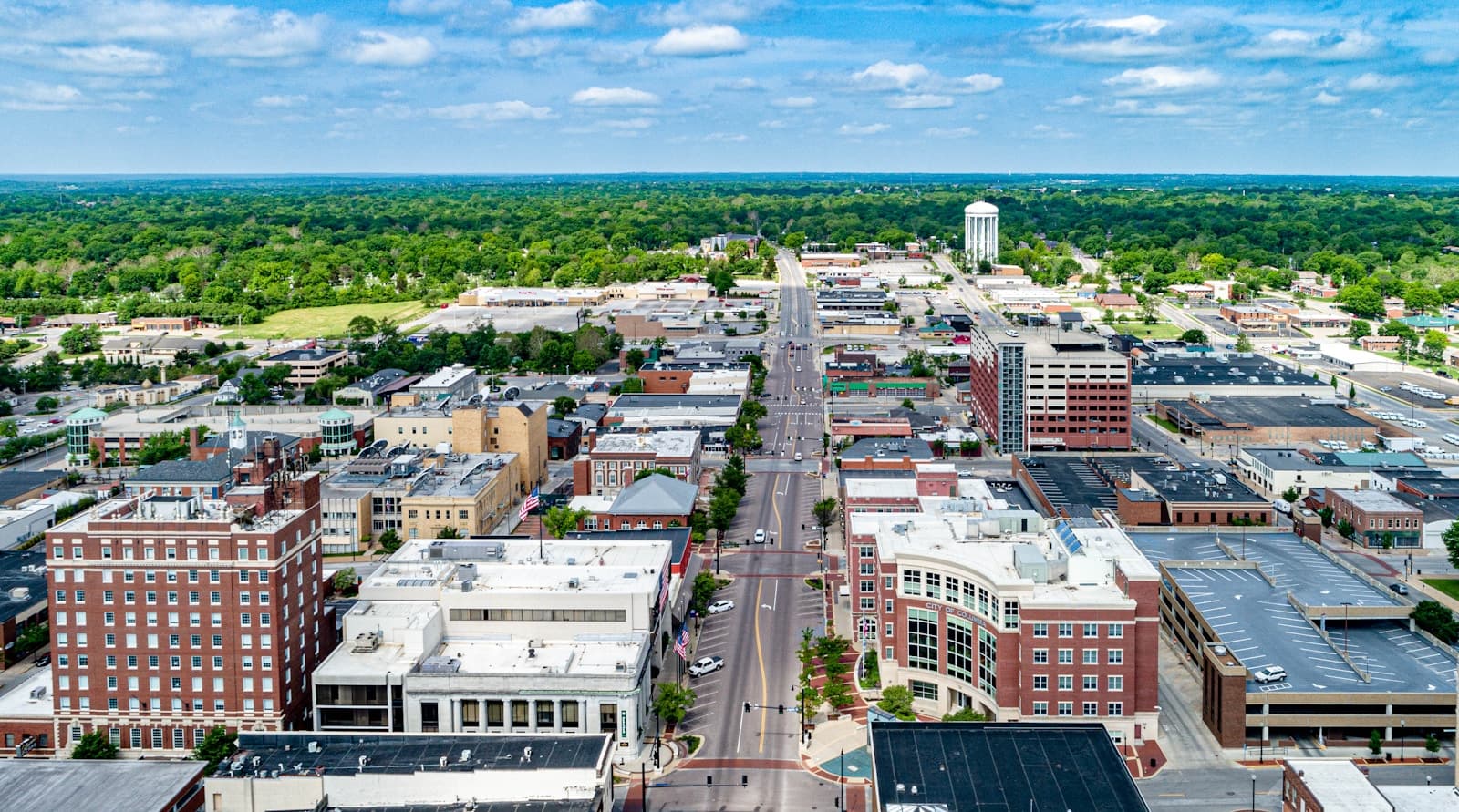 Aerial view of downtown area with brick buildings, main street, and surrounding green neighborhoods