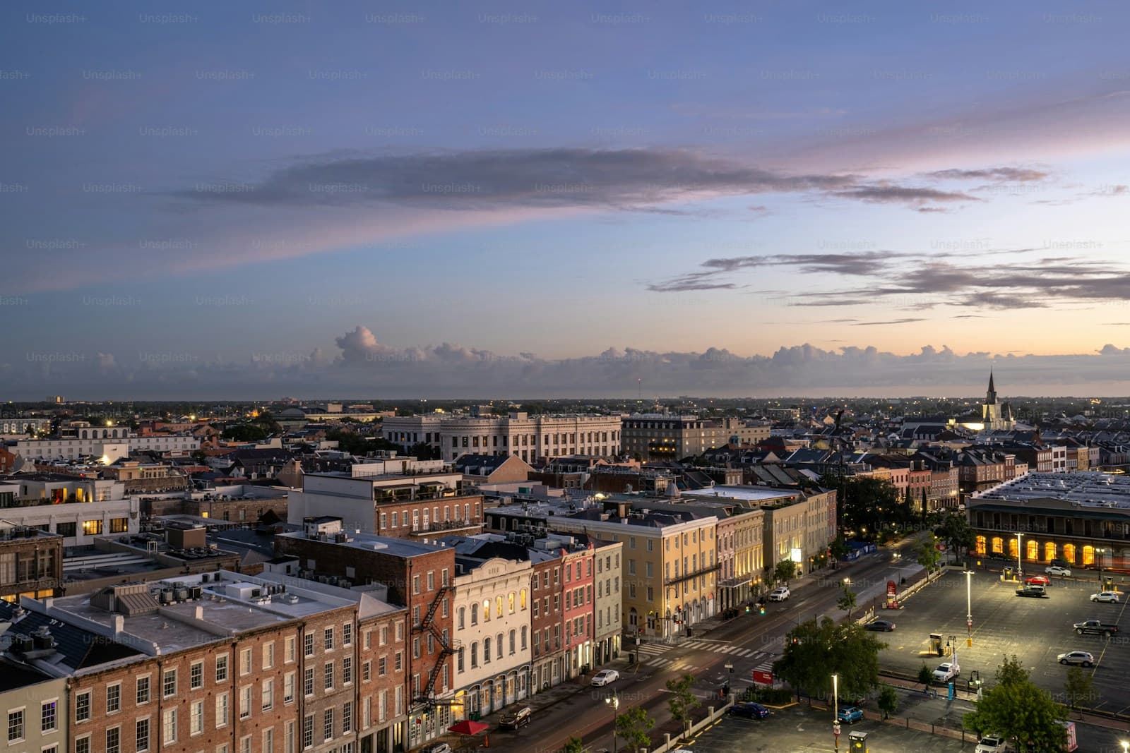 Aerial view of small town downtown with brick buildings at sunset under purple and pink sky