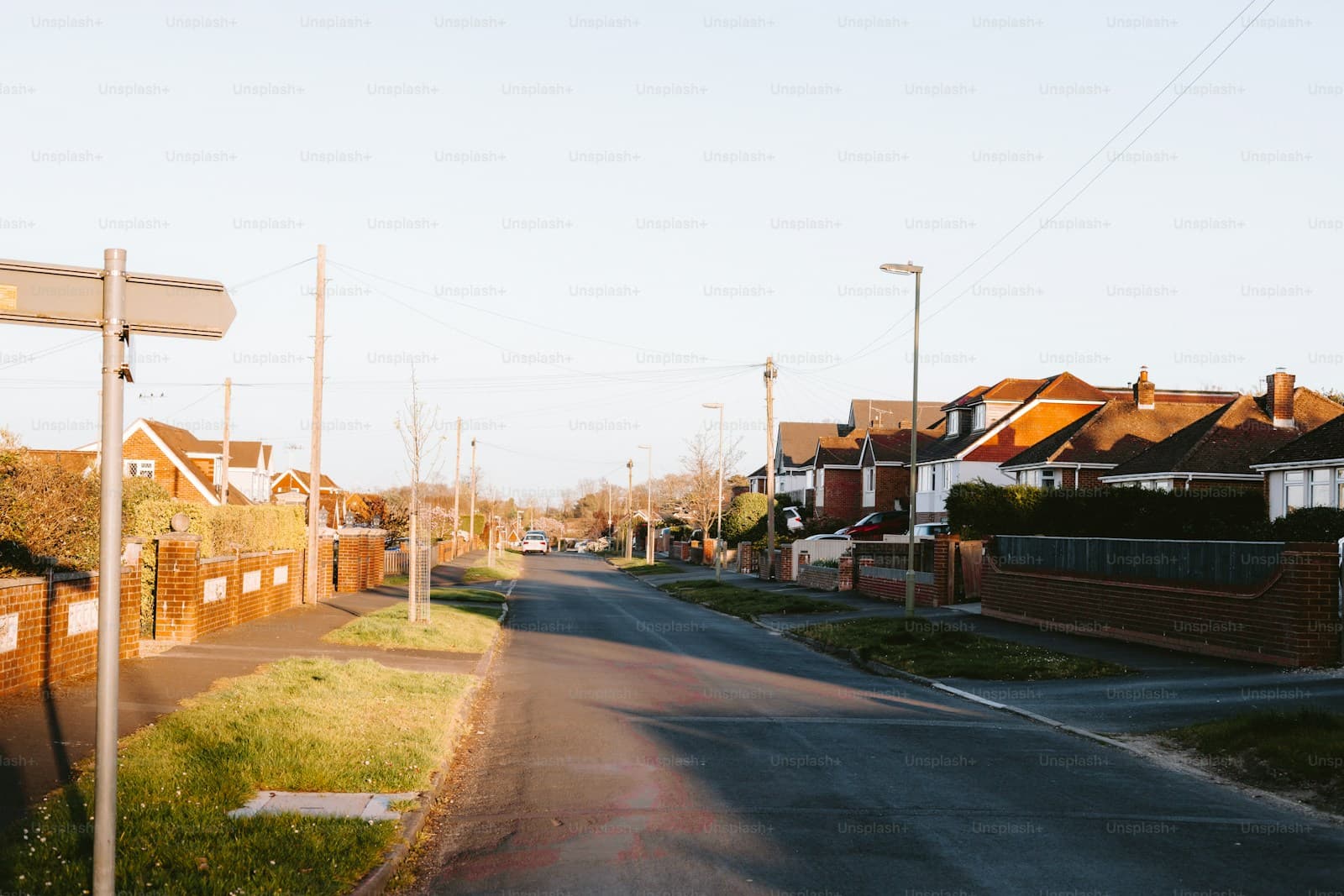Suburban street with houses and orange tile roofs during golden hour lighting