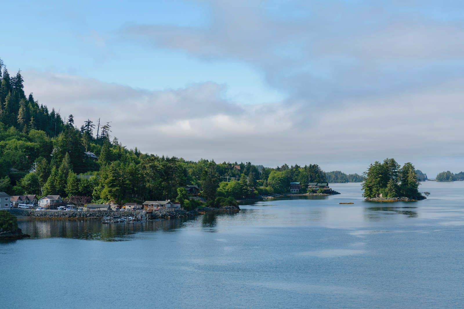 Peaceful lake surrounded by forested hills and small islands with houses nestled among green trees