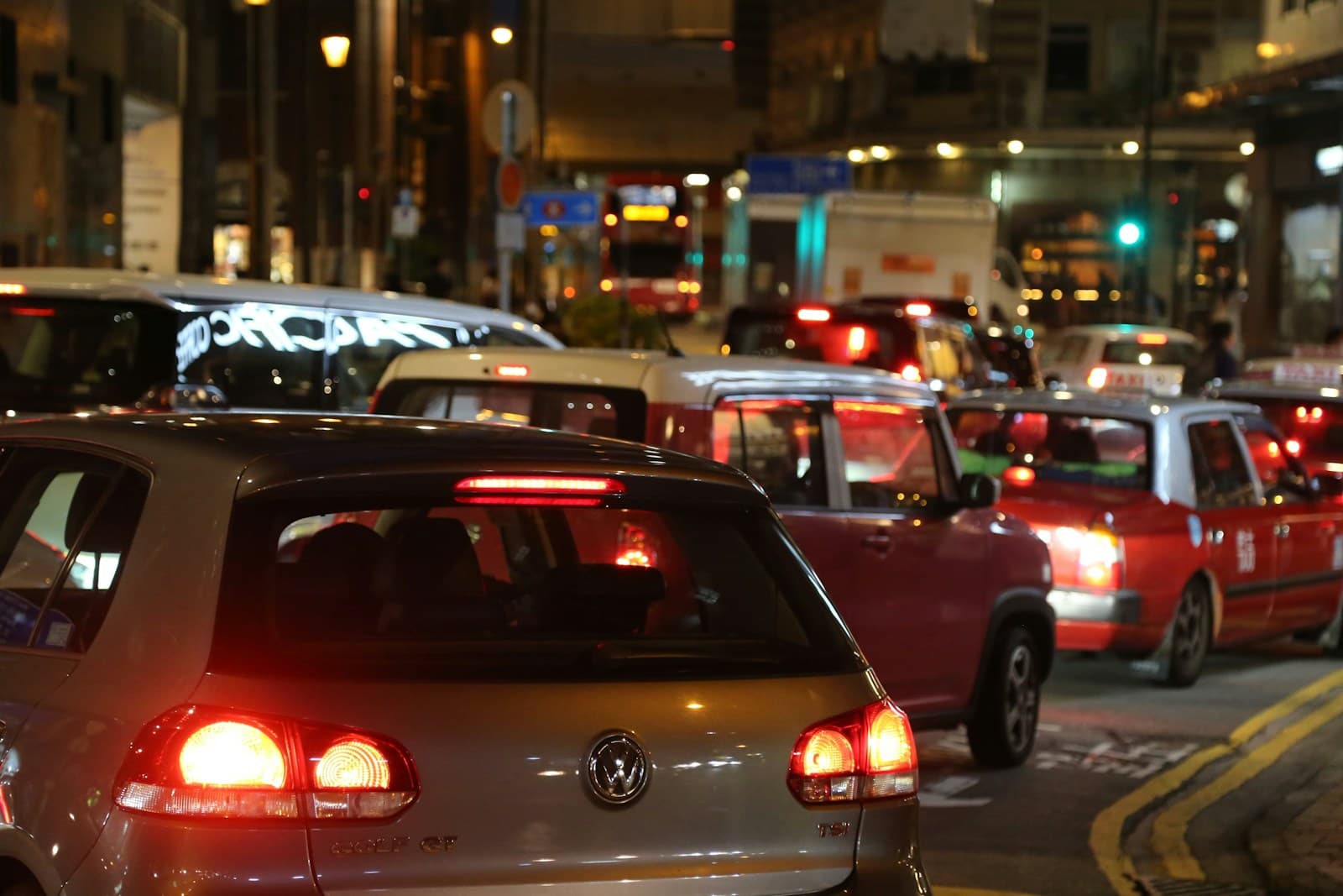 Heavy traffic jam at night with cars showing red brake lights on a busy city street